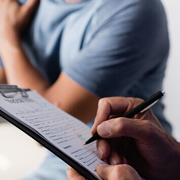 Person writing on clipboard