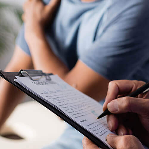 Person writing on clipboard