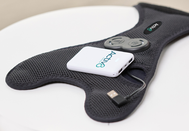 Activ8 battery resting on an Activ8 Knee device with the logo facing up.