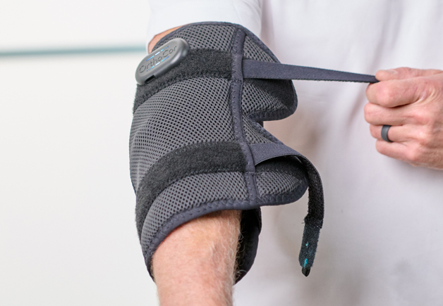 Man putting on an OrthoCor Elbow Active System